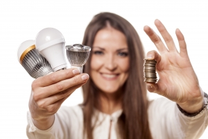 girl holding the LED bulbs in one hand and coins in the other